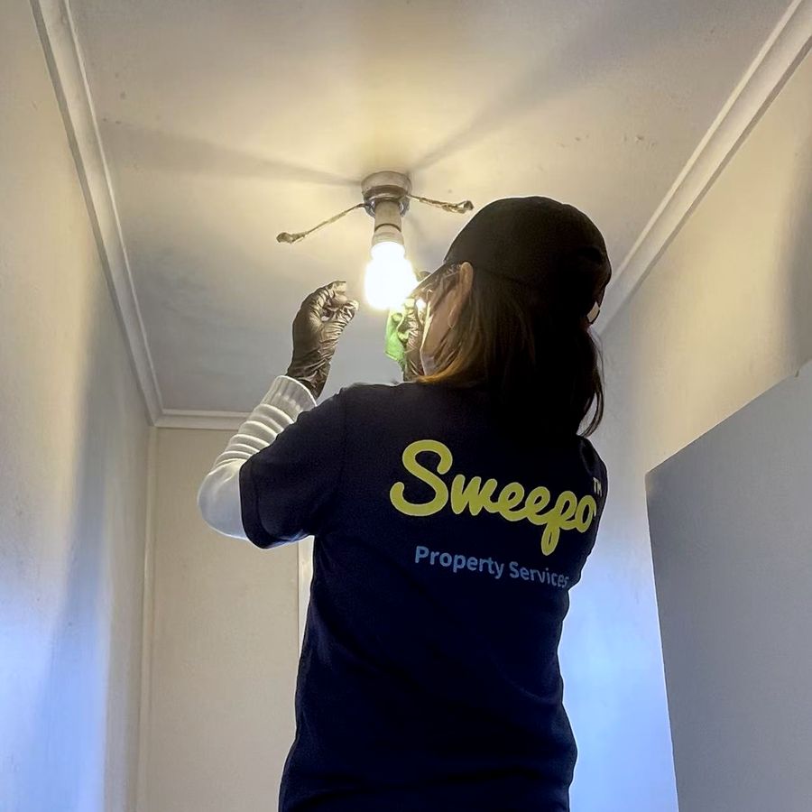 Sweepo team member fixing a ceiling light